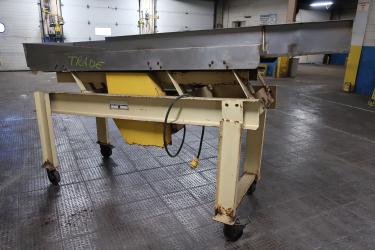 Feeder 24 w x 111 L and narrows to 12 1/2  Newcombe Enterprises vibratory feeder model Serial #581-014A1381, Stainless Steel